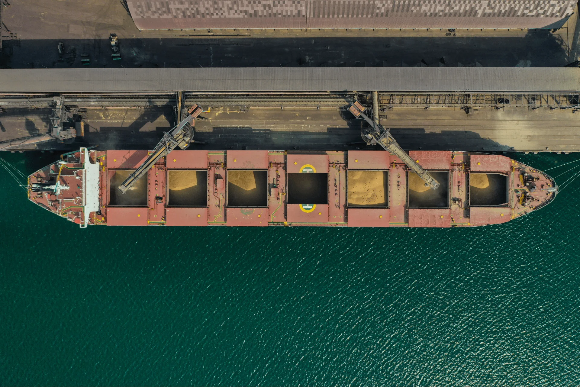 Bulk cargo vessel alongside port loading infrastructure